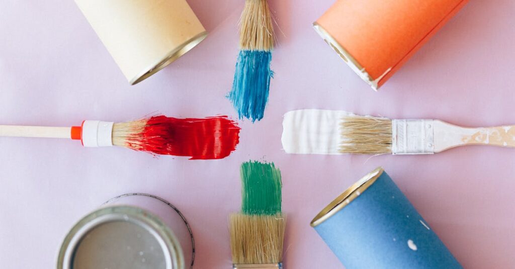 Top view of vibrant paintbrushes and cans against a pastel backdrop, ideal for creative projects.